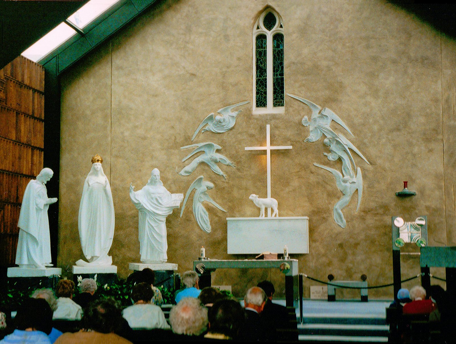 Interior of Knock Basilica featuring religious statues and altar during a service.